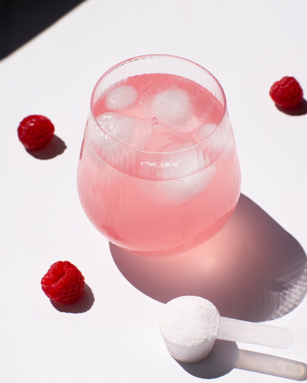 glass of pink iced drink made from vilgain electrolytes with raspberry lemonade flavor