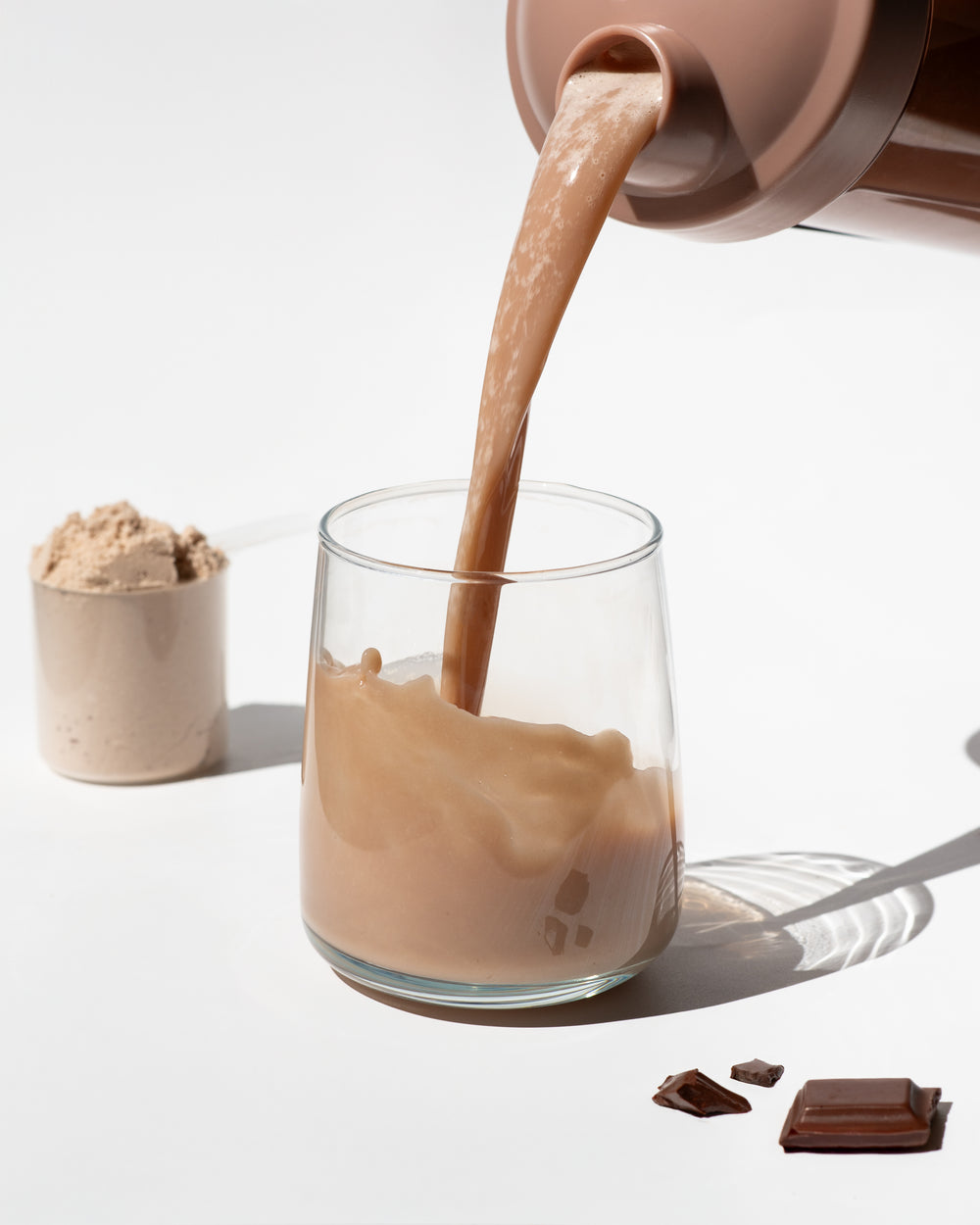 vilgain grass-fed whey protein with chocolate flavor being poured into a glass showing creamy texture