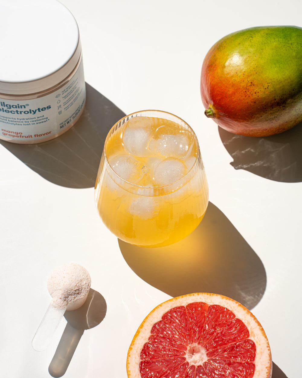 glass of yellow iced drink made from vilgain electrolytes with mango grapefruit flavor